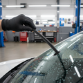 Mechanic installing new windshield wiper blade on car windshield