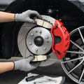 Close-up of car front brake caliper and rotor with new ceramic brake pads being installed