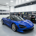 Freshly detailed car gleaming under showroom lights with deep paint reflection and glossy tires