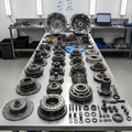 Disassembled automatic transmission with gears, clutch packs, and components laid out on clean workbench